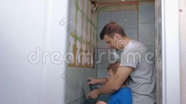 爸爸和儿子在家里一起做装修，把厕所里的墙上的瓷砖去掉。